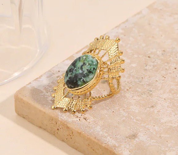 Bague dorée ajustable style solaire avec pierre ovale verte et détails ciselés