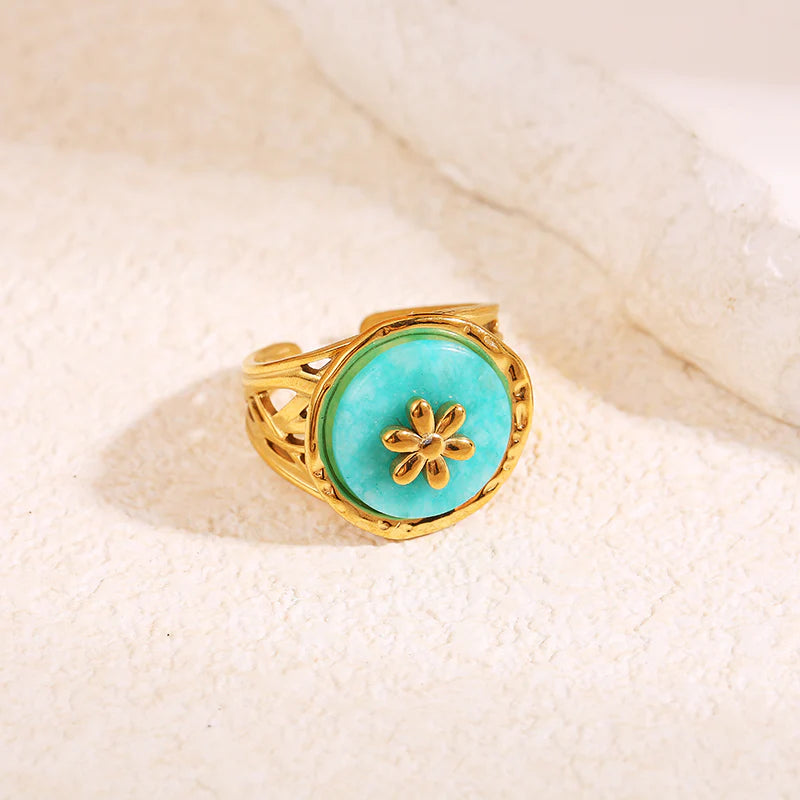 Bague dorée pierre ronde bleue avec fleur interne