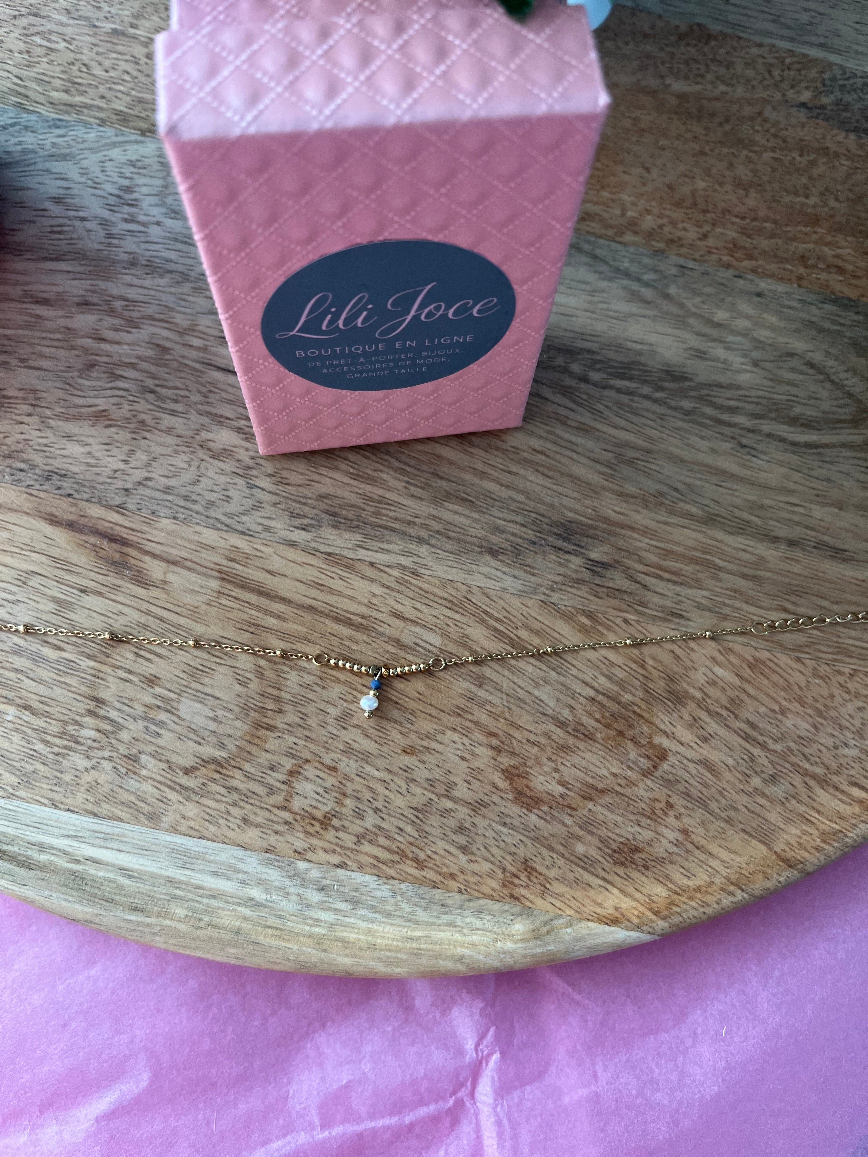 Bracelet doré avec pendentif en lapis-lazuli et pierre blanche – Élégance et équilibre
