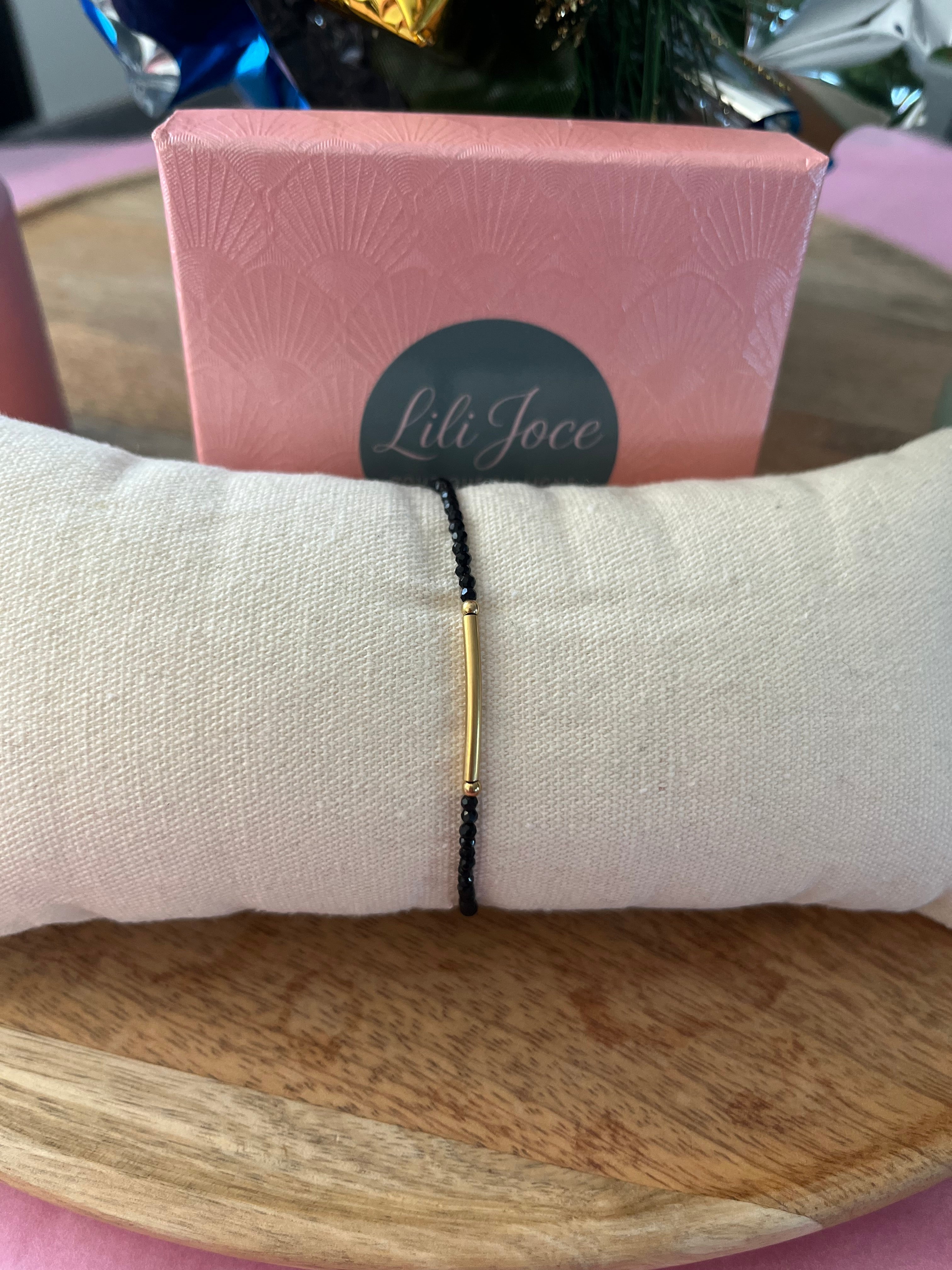 Bracelet en pierres noires avec barre dorée – Élégance minimaliste